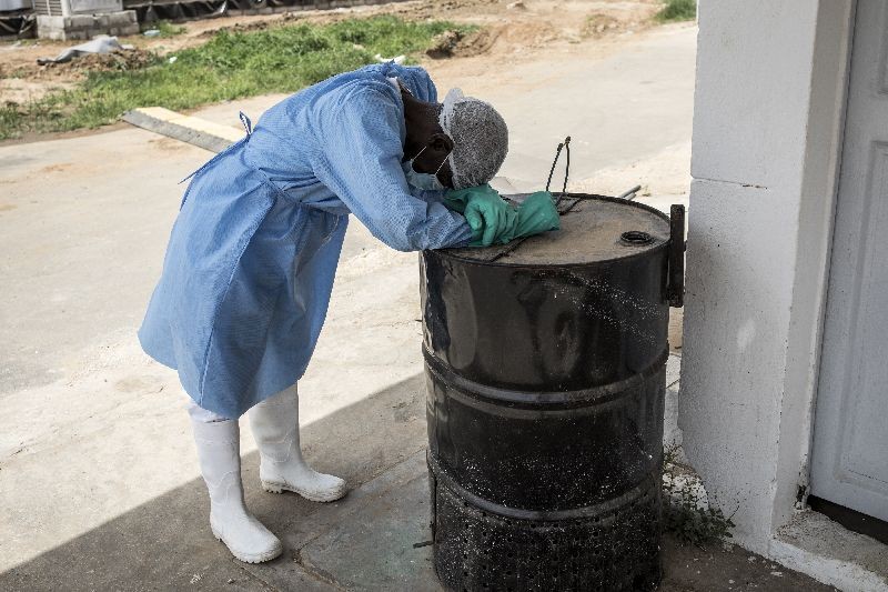 A hygienist rests as he waits outside a decontamination area in a COVID-19 coronavirus treatment centre that cares for positive patients that show little or no symptoms in Dakar . (Photo by John Wessels/AFP Photo)